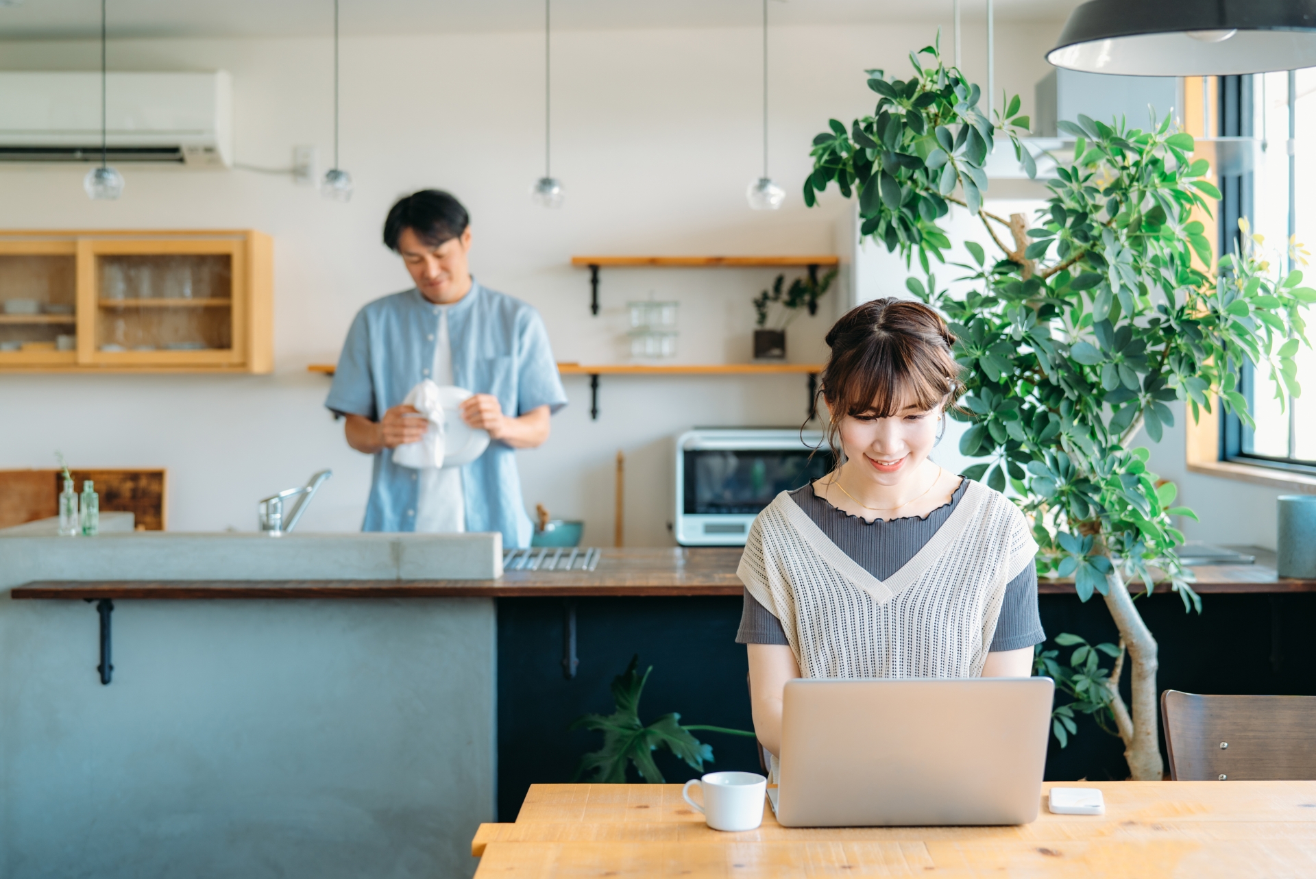 仕事をする妻と家事をする夫